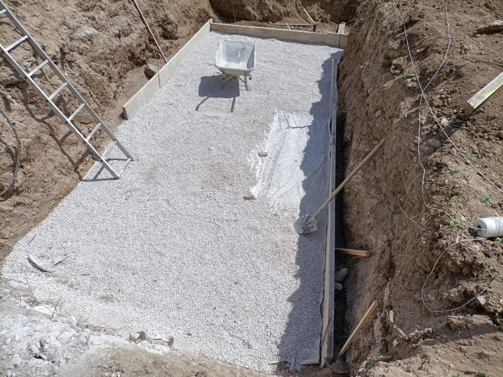 Fond de fouille dressé avec hérisson de gravier drainant et coffrage bois de semelle, prêt au coulage