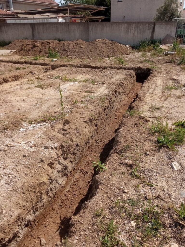 Tranchée de fondation ouverte, fond de fouille à nettoyer et dresser avant le béton de propreté