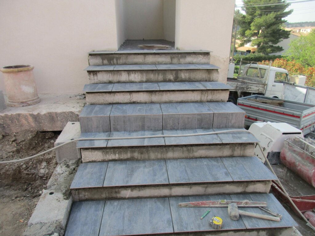 Escalier extérieur habillé en pierre bleue avec joints en cours de finition