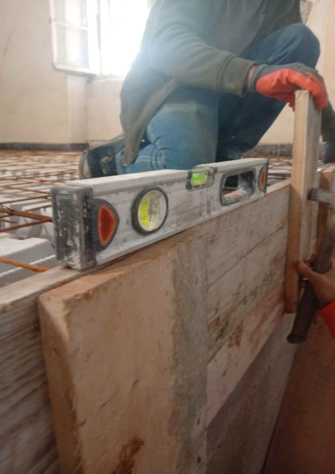 Niveau posé sur une planche lors d'une extension maçonnée