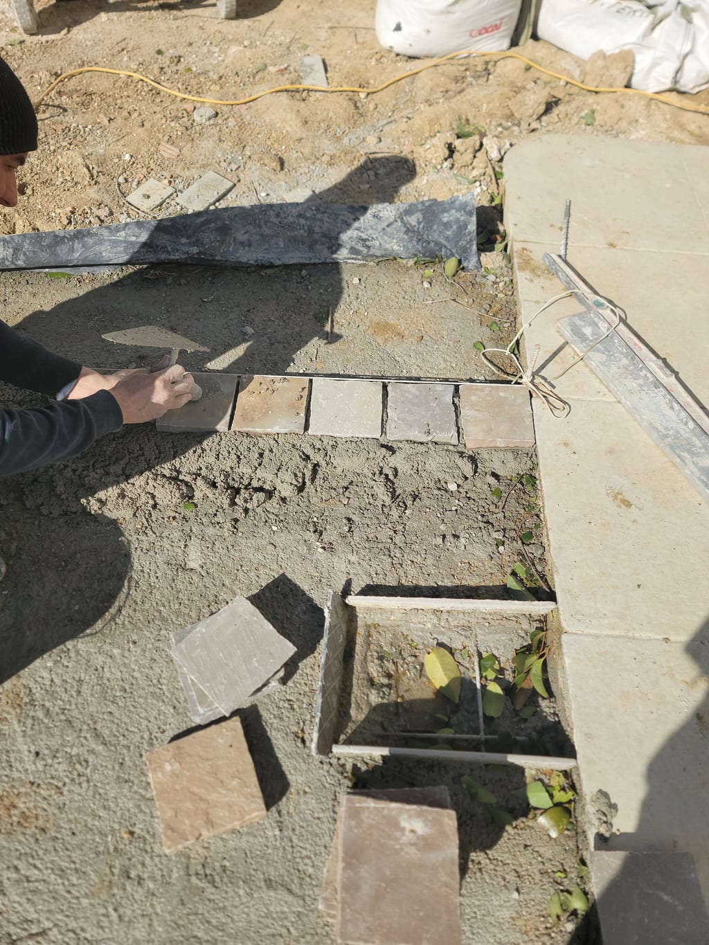 Premiers pavés en cours d'alignement sur cordeau