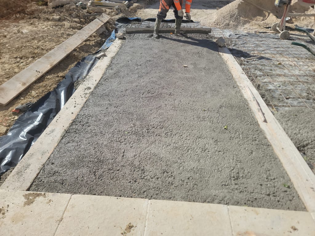 Dalle béton fraîchement tirée à la règle — surface support pose pavés