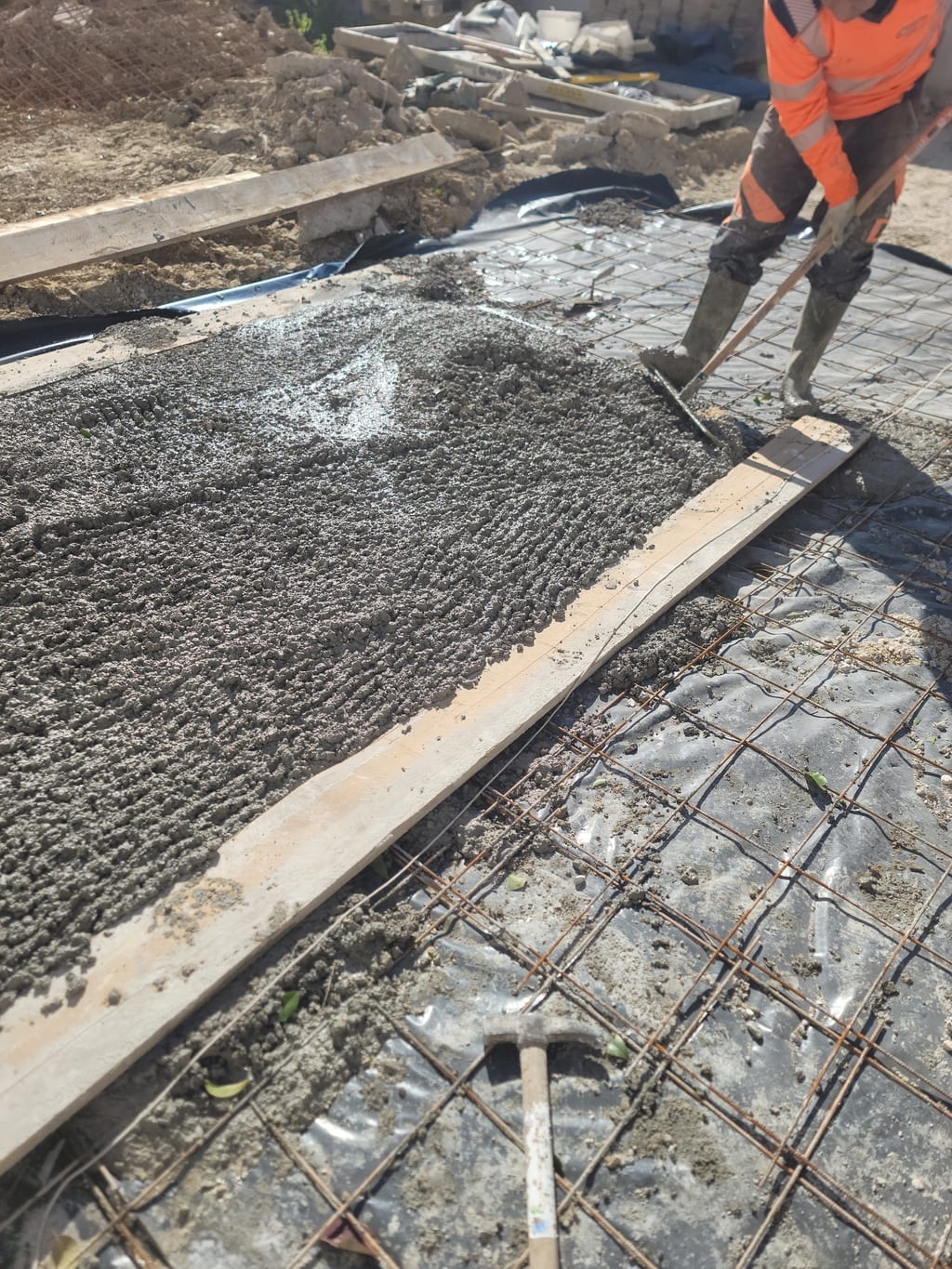 Préparation du fond de forme et du hérisson compacté avant coulage d'une allée carrossable en béton