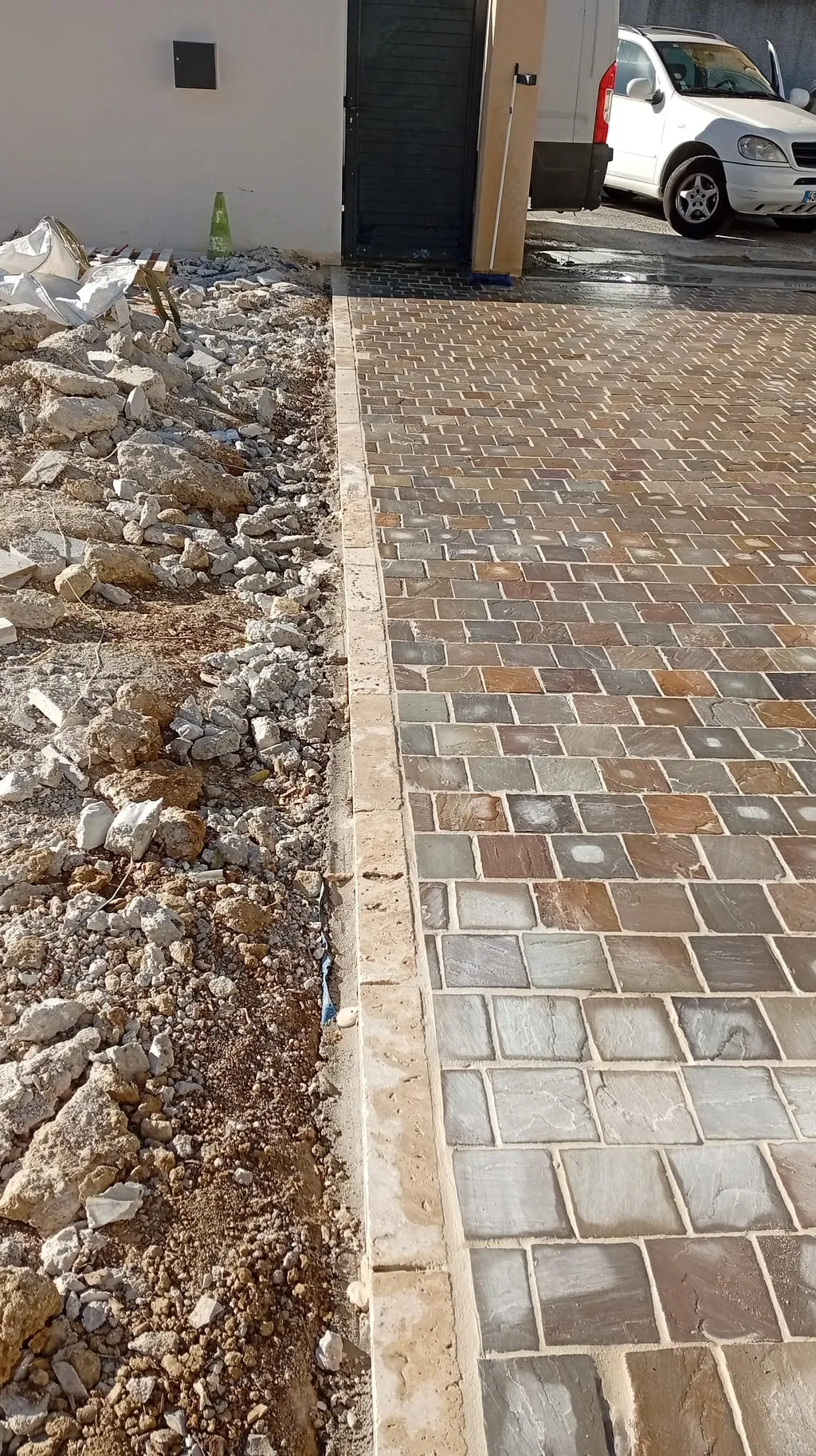 Allée bordée d'une bande de cailloux le long d'un mur