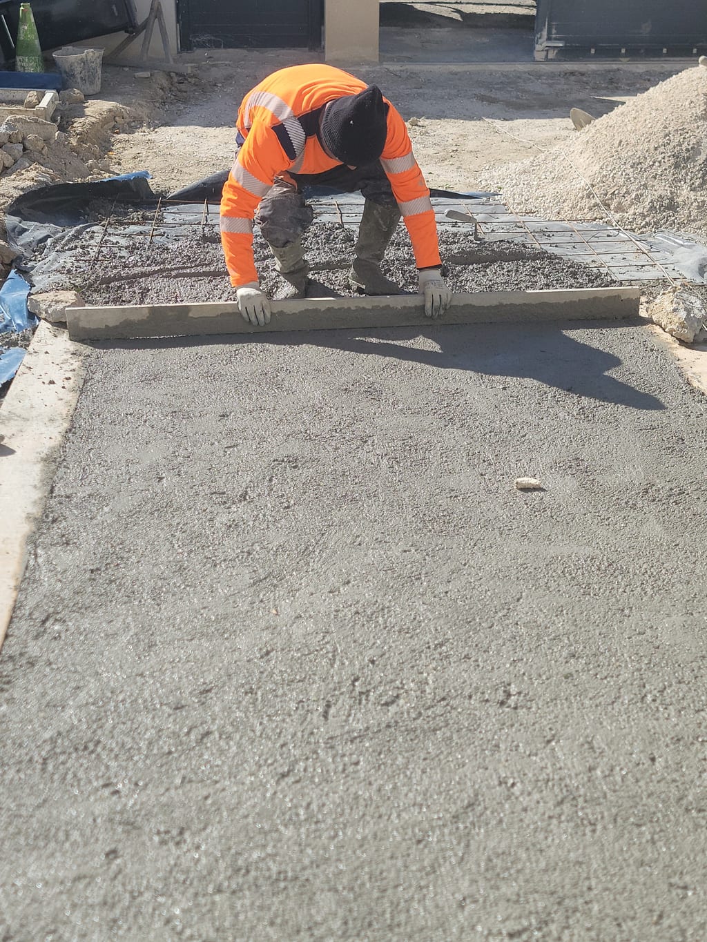 Tirage du béton à la règle métallique — finition surface dalle Saint-Barnabé