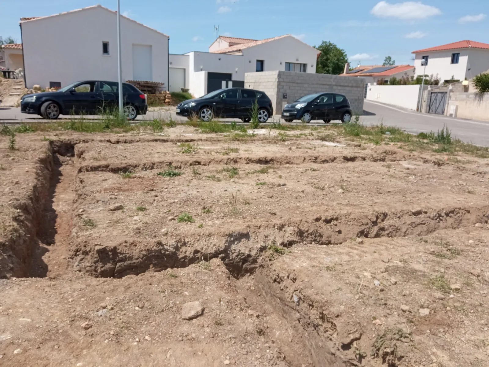 Fouilles de fondation et terres extraites en bordure de tranchée