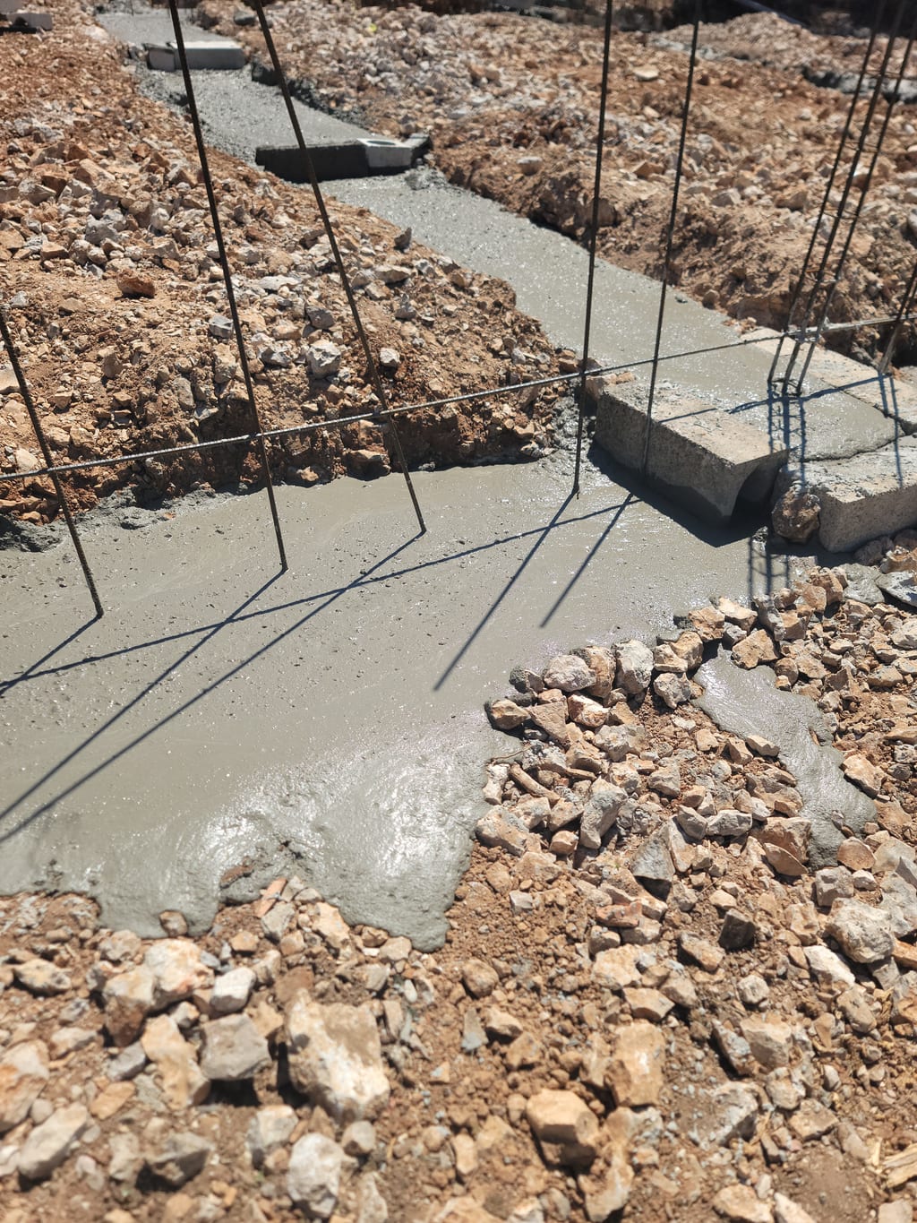 Gros plan béton frais entre les agglos et attentes chaînage vertical