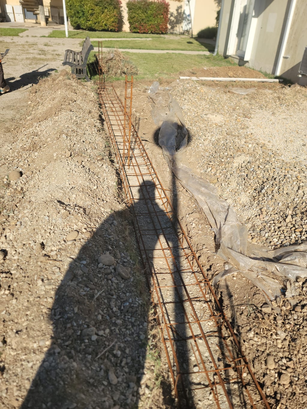 Vue large terrain et fouille périphérique avec ferraillage en cours — limite parcelle Arles 13200