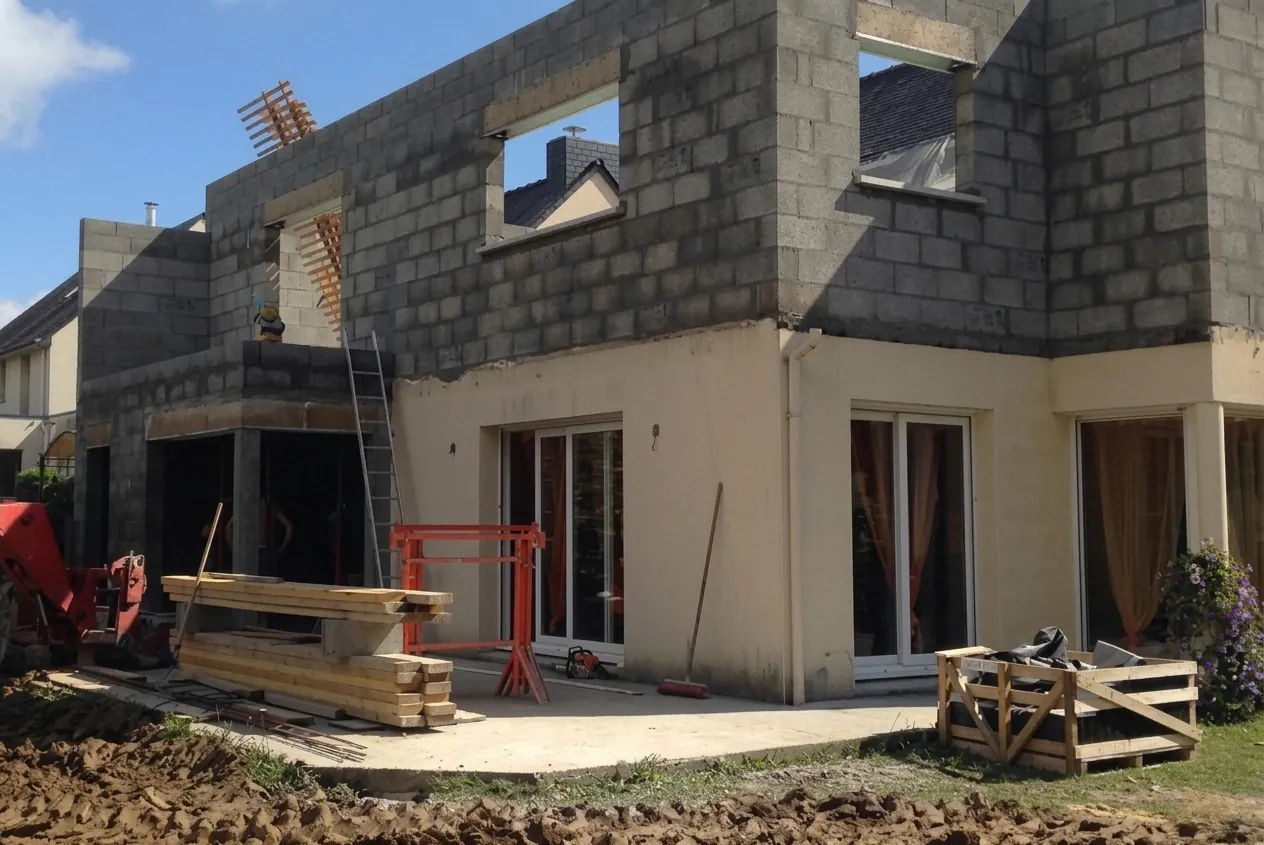 Extension de maison avec étage en cours — structure parpaing R+1, ouvertures en attente d'enduit · chantier Les Maisons Vertes Provençales