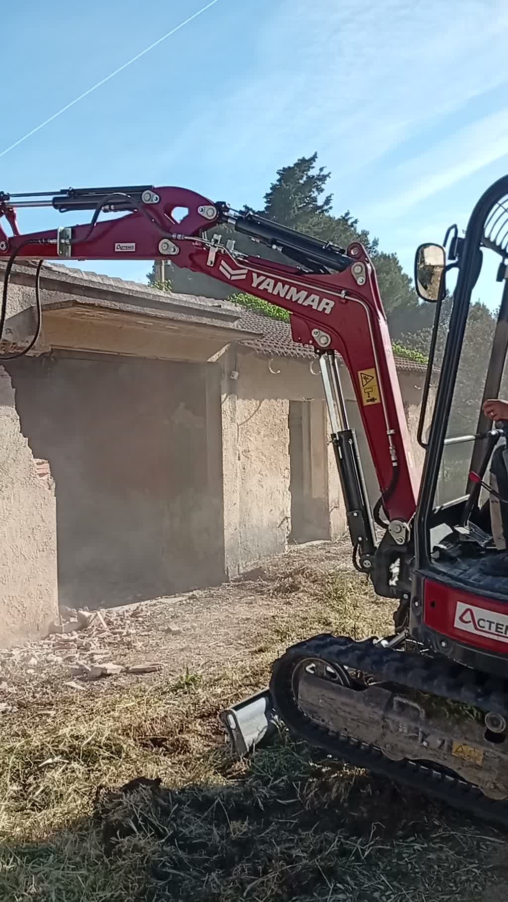 Brise-roche hydraulique démolissant un mur de la villa de Vitrolles, gravats au sol