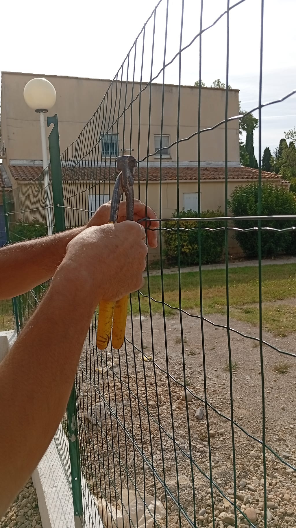 Agrafage du grillage soudé sur le fil de tension avec pince tendeuse — clôture souple Miramas