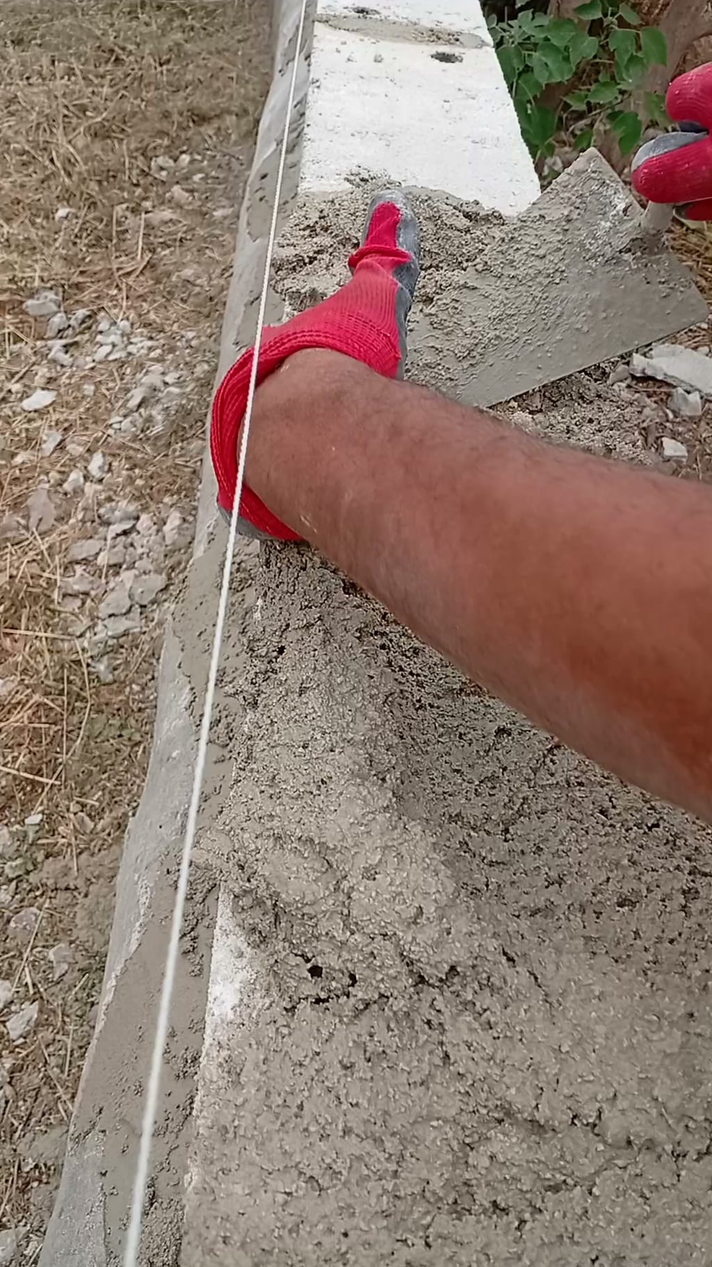 Étalement du mortier à la main gantée sur l'arase du mur de clôture de 55 m aux Pennes-Mirabeau