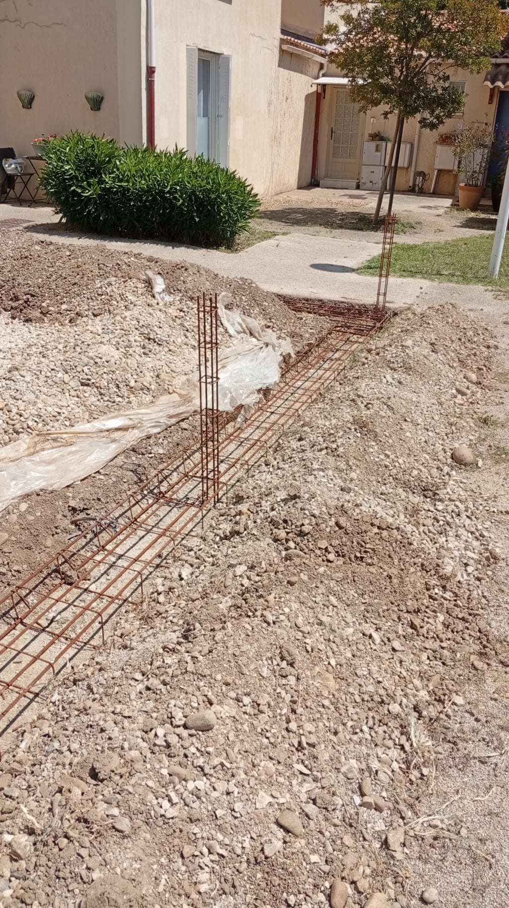 Tranchée de fondation et ferraillage avec poteau raidisseur pour muret de clôture à Miramas