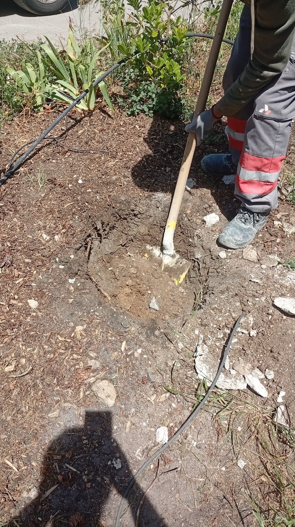 Fouille d'un plot de scellement creusée à la pioche pour poteau de grillage rigide aux Pennes-Mirabeau