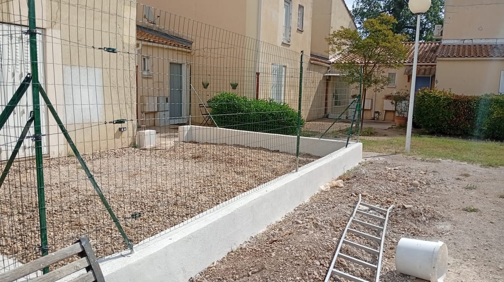 Clôture sur muret enduit dans un jardin gravillonné de lotissement, secteur Salon-de-Provence
