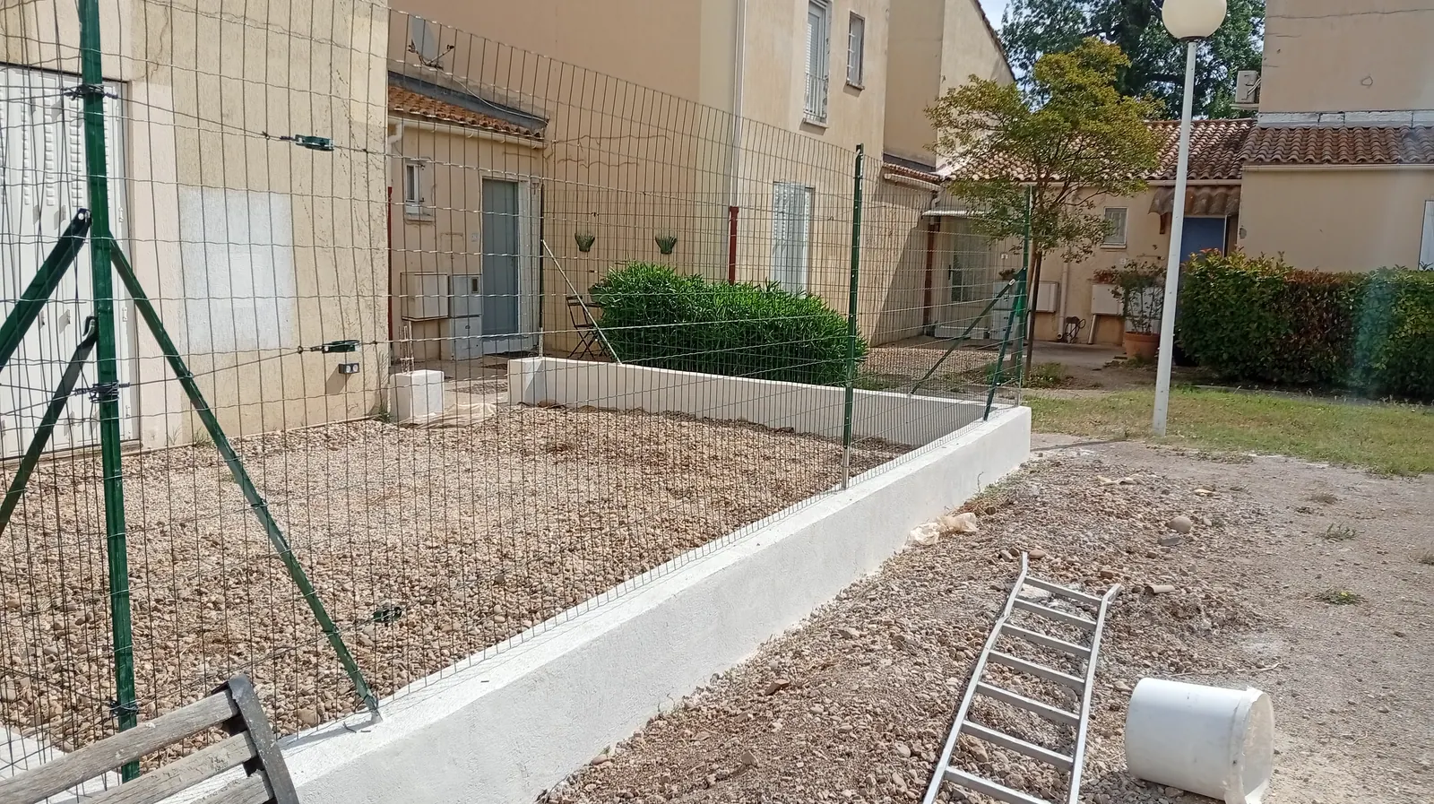Clôture grillage souple sur muret enduit délimitant un terrain au pied de la Sainte-Victoire à Trets