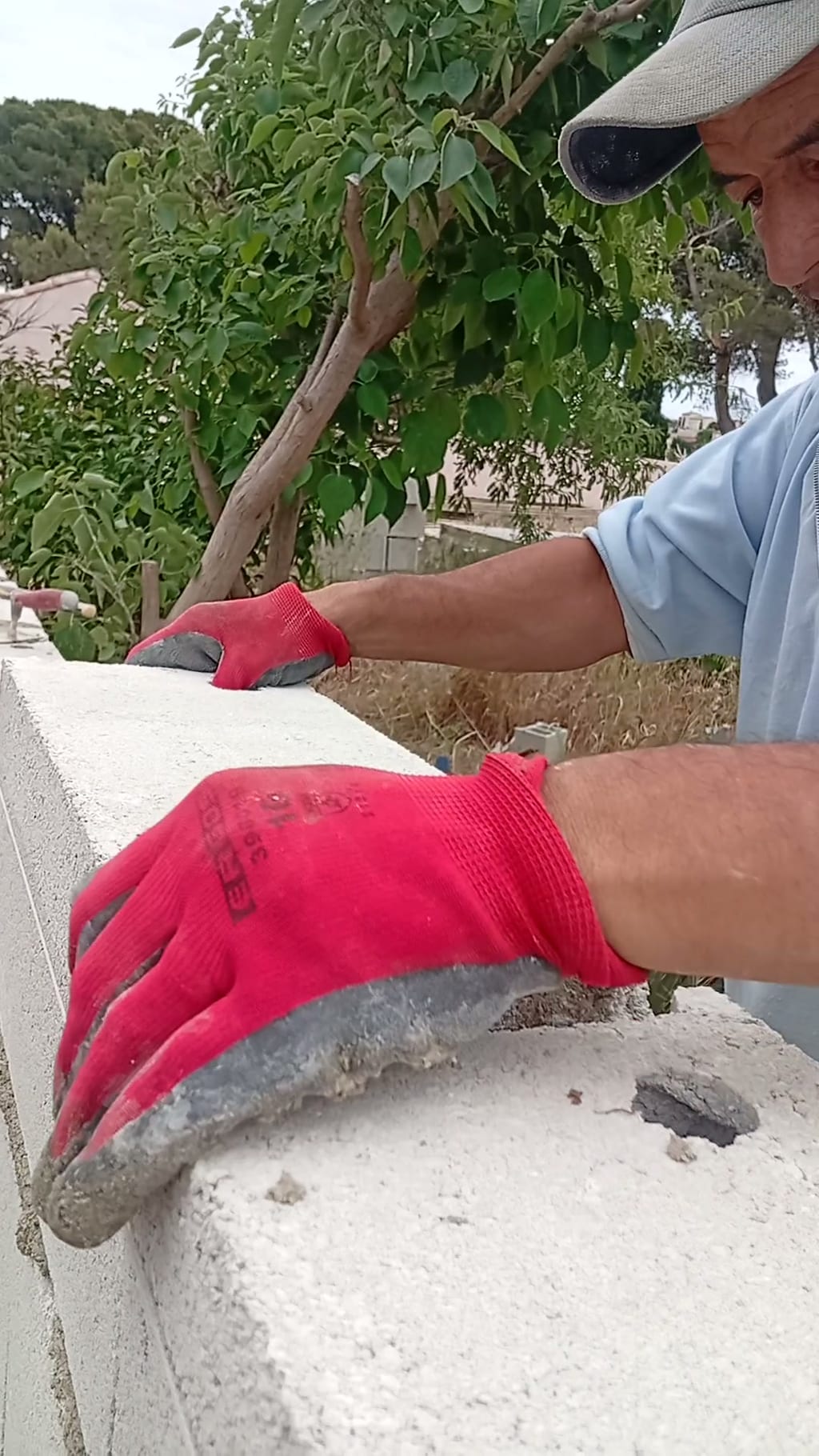 Pose d'un élément de couronnement sur bain de mortier frais, mur de clôture des Cadeneaux
