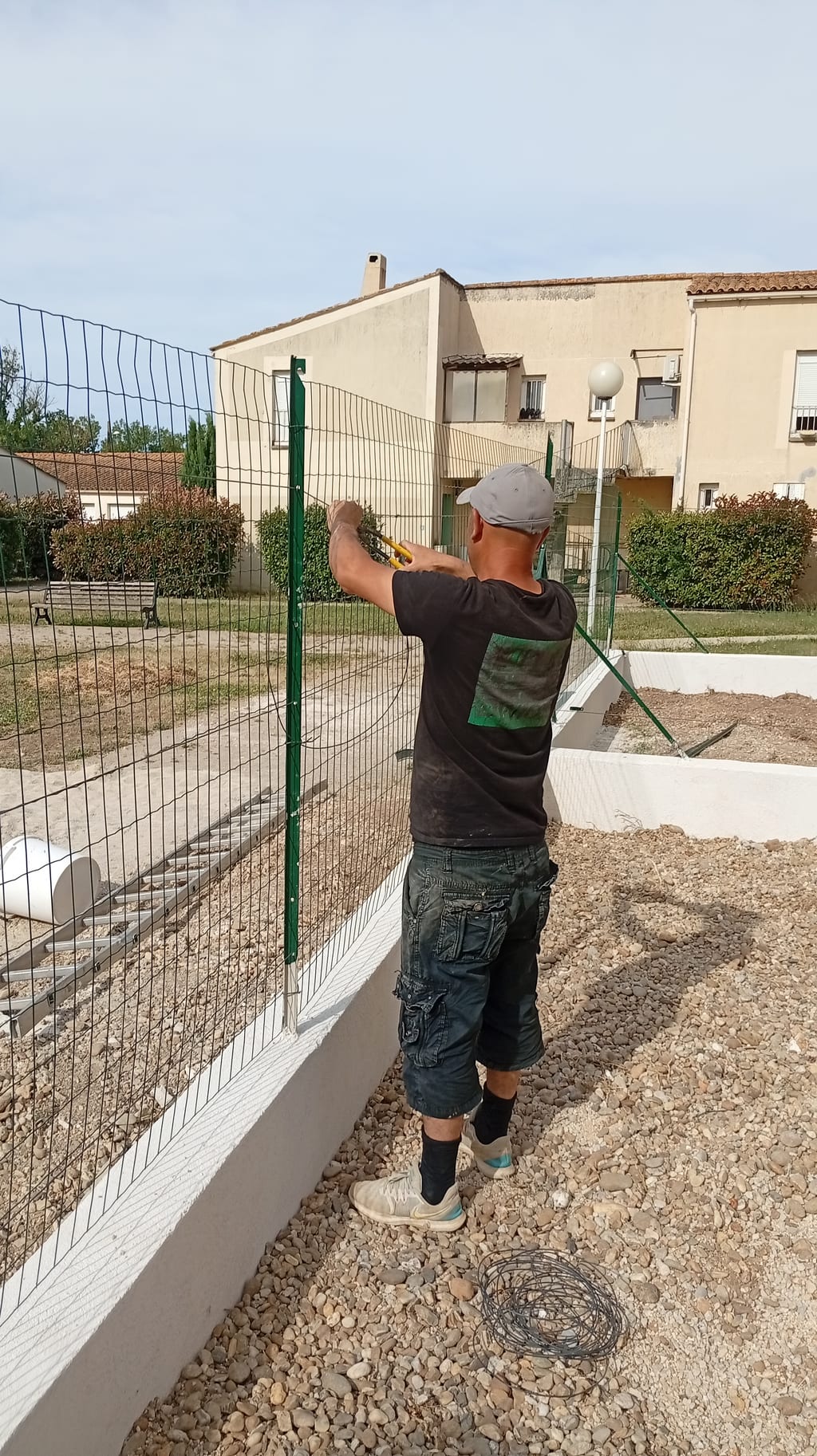 Pose d'un grillage souple sur muret en agglo le long d'une grande limite de terrain aux Pennes-Mirabeau
