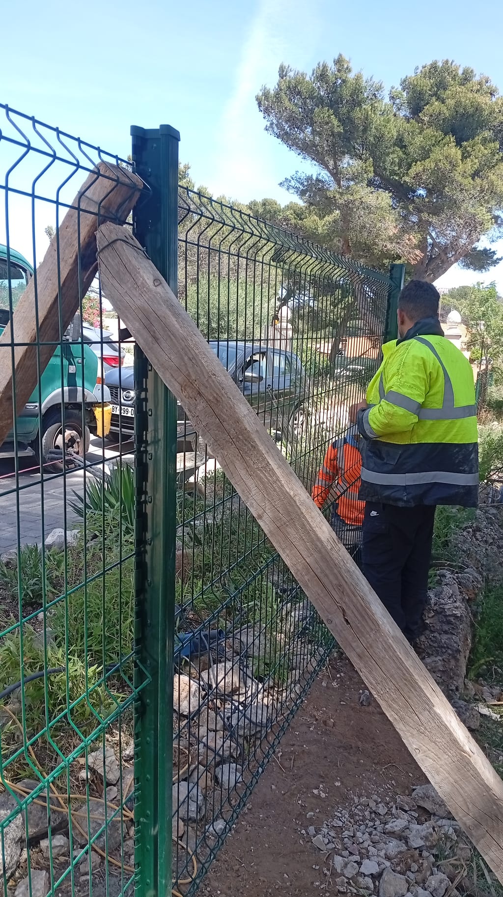 Réglage d'un panneau de grillage rigide vert RAL 6005 sur son poteau, étai bois en place — Les Pennes-Mirabeau