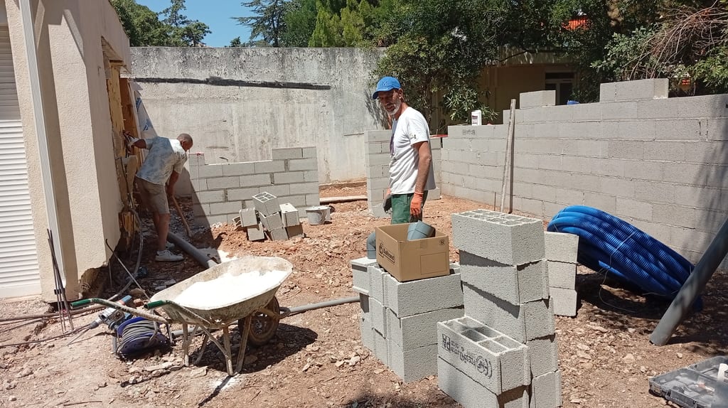 Montage des murs en agglo creux de l'extension contre la maison existante — chantier avenue du Lapin Blanc Marseille 13008, juillet 2026