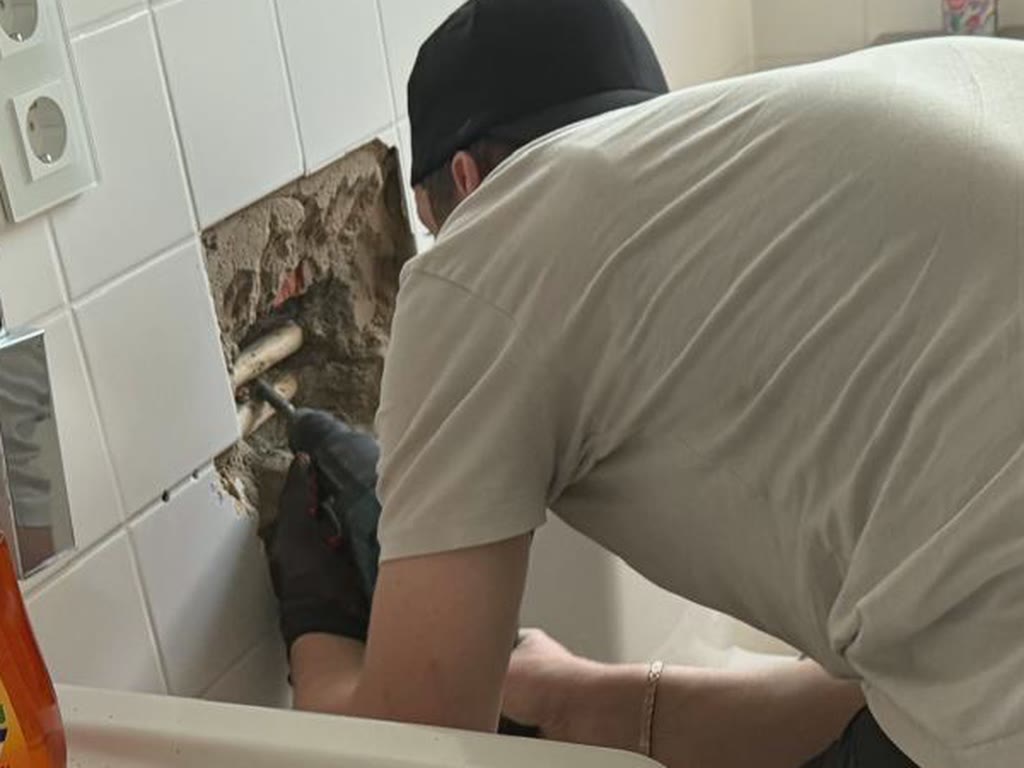 Illustration : mur carrelé ouvert pour atteindre une canalisation encastrée